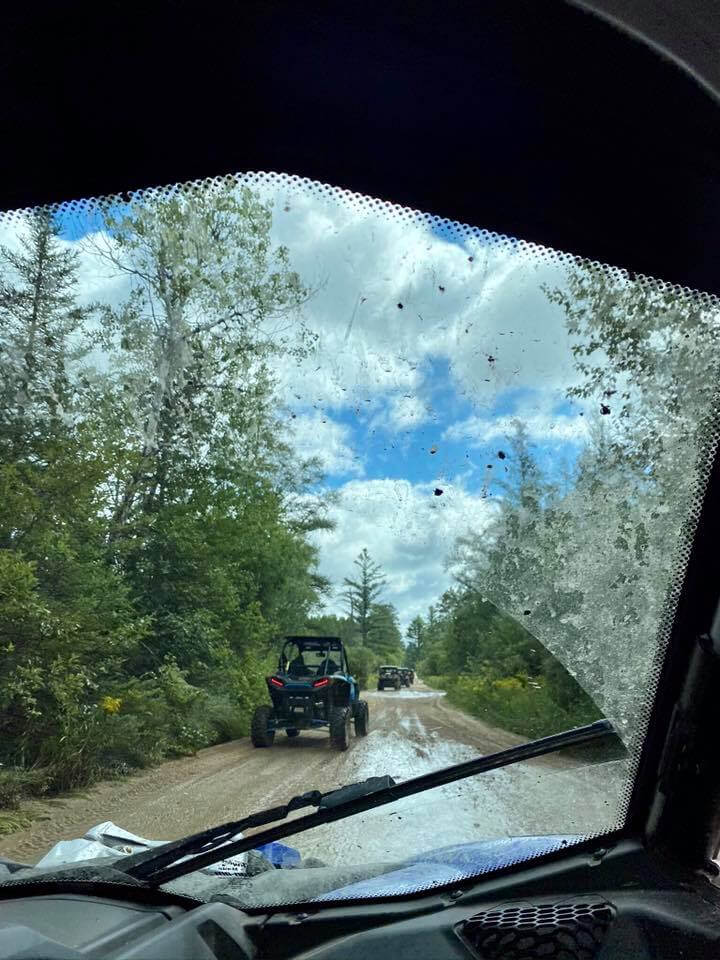 A buggy driving down the road in front of trees.